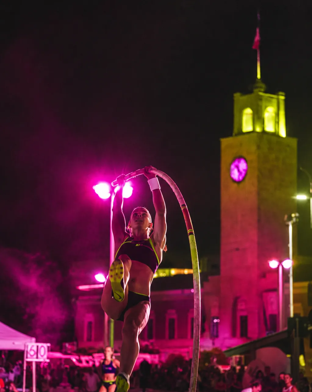 Atleta durante una competizione serale di salto con l'asta
